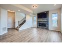 Bright living room featuring a fireplace, TV, neutral walls, and beautiful laminate floors at 16881 Roaming Elk Dr, Monument, CO 80132