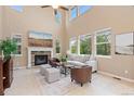 Spacious living room featuring a stone fireplace, large windows, and comfortable seating at 14278 Greenfield Loop, Parker, CO 80134