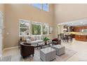 Open-concept living room with high ceilings, ample natural light, and a view of the dining area at 14278 Greenfield Loop, Parker, CO 80134