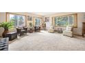 Bright living room featuring large windows with scenic views, plush carpeting, and cozy seating arrangements at 10049 S Turkey Creek Rd, Morrison, CO 80465