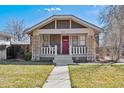 Inviting home exterior with a covered front porch and a well-maintained lawn at 3210 S Washington St, Englewood, CO 80113