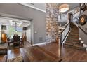 Elegant foyer showcasing a stone accent wall and staircase to upper level at 7243 S Kellerman Way, Aurora, CO 80016