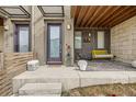 Inviting front porch with a comfortable seating area, stylish decor, and a welcoming entrance at 5676 Emporia St, Denver, CO 80238