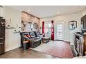 Charming living room featuring a brick accent wall, comfortable seating, and access to a balcony at 5676 Emporia St, Denver, CO 80238