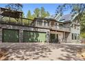 Exterior of home with a three-car garage with matching green doors and stone accents at 7317 Fremont Pl, Larkspur, CO 80118