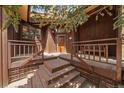 Inviting home entryway with wooden stairs and natural wood siding at 3251 Interlocken Dr, Evergreen, CO 80439