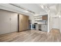 Spacious living area with a Murphy bed, wood floors, and adjacent kitchen area with stainless steel appliances at 1495 Vrain St # 115, Denver, CO 80204