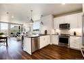 Modern kitchen with stainless steel appliances, white cabinets, and an open layout to the living area at 20 Wilcox St # 410, Castle Rock, CO 80104