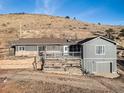 Charming gray house with a front deck, mature trees, and a partial garage at 208 Wark Ave, Berthoud, CO 80513