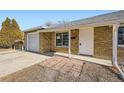 Front view of a ranch home with a white door and attached garage at 1230 Peoria St, Aurora, CO 80011