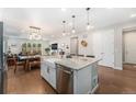 Spacious kitchen featuring an island with a sink and dishwasher, open to the dining and living areas at 5331 Routt Ct, Arvada, CO 80002
