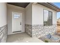 Up-close view of a front entry door with stone veneer siding, showcasing the modern exterior details at 15 S Gray St, Lakewood, CO 80226