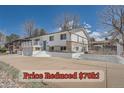 Charming home with white exterior, complemented by brick accents and a spacious driveway at 4090 S Tamarac Dr, Denver, CO 80237