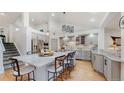 Spacious kitchen featuring gray cabinets, mosaic tile backsplash, stainless steel appliances and center island with seating at 6503 Big Horn Trl, Littleton, CO 80125