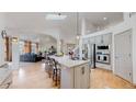 Open concept kitchen with stainless steel appliances, center island with barstool seating and open access to living area at 6503 Big Horn Trl, Littleton, CO 80125