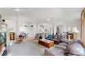 Bright, open living room showcases stairs, a ceiling fan, hardwood floors, and inviting seating area at 6503 Big Horn Trl, Littleton, CO 80125