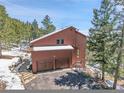 Spacious home with an attached two-car garage surrounded by mature trees at 27100 Molly Dr, Conifer, CO 80433