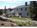 Backyard features a stone patio perfect for entertaining, a sprawling lawn, and mature trees at 2879 Gold Creek Dr, Elizabeth, CO 80107