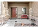 Front porch with a red bench and stone columns at 14240 Ivanhoe St, Thornton, CO 80602