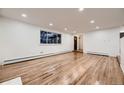 Inviting living room featuring hardwood floors, recessed lighting, and large windows at 3318 S Dayton Ct, Denver, CO 80231