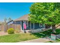 Inviting home exterior showcasing a welcoming porch, American flag, and beautiful landscaping at 2791 Quarterland St, Strasburg, CO 80136
