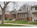 Beautiful brick home featuring a well-maintained lawn and a charming covered porch at 1023 S High St, Denver, CO 80209