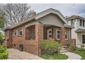 Classic brick home featuring a quaint covered front porch and manicured landscaping at 1023 S High St, Denver, CO 80209
