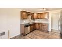 Well-lit kitchen featuring stainless steel appliances, granite countertops, and wood floors at 2201 S Holly St # 1, Denver, CO 80222
