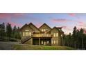 Back of the beautiful home with a large deck perfect for entertaining and enjoying scenic views at 30041 Marys Dr, Conifer, CO 80433