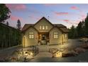 Inviting front view of the home with manicured landscaping and stone pathway with beautiful pink sky at 30041 Marys Dr, Conifer, CO 80433