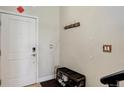 Bright entryway with a white door, coat hooks, a bench, and easy access at 3040 Zuni St # F, Denver, CO 80211