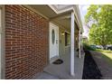 Close-up of the home's entrance featuring a decorative front door, brick accents, and covered porch at 2120 S Ouray St, Aurora, CO 80013