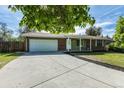Well-kept single-story home with a large driveway, attached garage, and lush green lawn at 2120 S Ouray St, Aurora, CO 80013