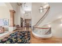 Grand foyer with hardwood floors, a curved staircase, and an elegant chandelier at 6722 S Wolff Ct, Littleton, CO 80128