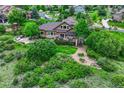 Spacious backyard featuring a large deck, stone patio, and lush greenery at 5424 Hacienda Pl, Parker, CO 80134