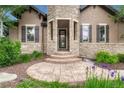 Charming entryway with stone pillars, a glass door, and steps leading to the entrance at 5424 Hacienda Pl, Parker, CO 80134