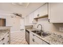 Kitchen featuring granite countertops, stainless steel sink, and white cabinetry at 931 S Zeno Way # 107, Aurora, CO 80017
