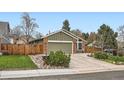 This cozy home features a well-manicured lawn, a two-car garage, and charming brick accents at 8101 S San Juan Range Rd, Littleton, CO 80127