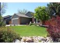Beautiful front yard with a lush green lawn and landscaping of a charming brick home at 8101 S San Juan Range Rd, Littleton, CO 80127