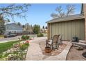 Inviting front porch featuring decorative concrete, chairs, and vibrant flower beds at 8101 S San Juan Range Rd, Littleton, CO 80127