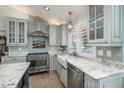 An updated kitchen boasts granite countertops, a stainless steel stove, a stainless steel hood, and updated cabinetry at 3488 Dawson Rd, Sedalia, CO 80135