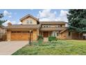Charming two-story home boasts a well-manicured lawn, mature trees, and attached two car garage at 5149 E Links Cir, Centennial, CO 80122