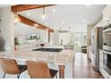 Spacious kitchen with barstool seating, stainless steel appliances, and light wood flooring at 5149 E Links Cir, Centennial, CO 80122