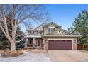 Charming two-story home with a stone facade, well-maintained landscaping, and attached two-car garage at 9882 S Hoyt Ct, Littleton, CO 80127