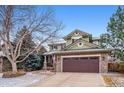 Charming two-story home features a covered porch, stone accents, and a two-car garage at 9882 S Hoyt Ct, Littleton, CO 80127