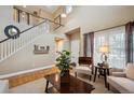 Living room with a view of the staircase and upstairs; neutral decor at 9882 S Hoyt Ct, Littleton, CO 80127
