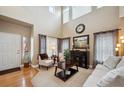 Inviting living room with large windows, neutral paint, and a view of the staircase at 9882 S Hoyt Ct, Littleton, CO 80127