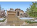 Charming home featuring a stone archway, two-car garage, and well-maintained landscaping at 15855 Wild Horse Dr, Broomfield, CO 80023