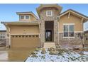 Inviting home featuring a stone tower entrance, well-kept landscaping, and a two-car garage at 15855 Wild Horse Dr, Broomfield, CO 80023