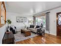 Bright living room featuring hardwood floors, a large window, and stylish decor at 7839 Florado St, Denver, CO 80221